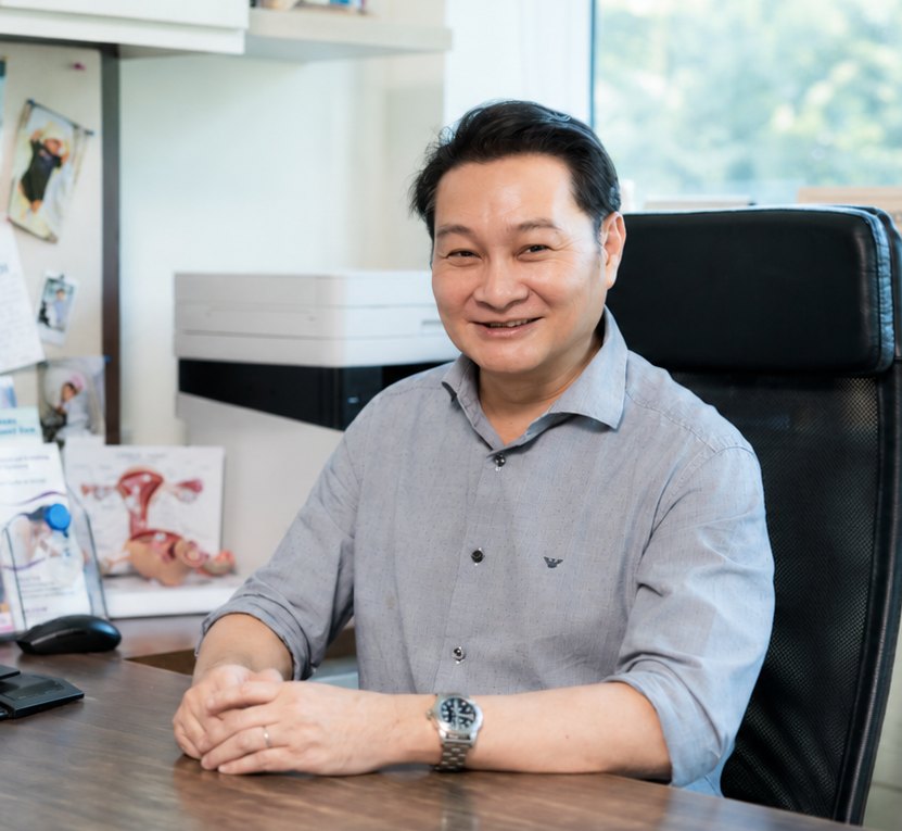 Dr Christopher Ng seated at his desk in the clinic